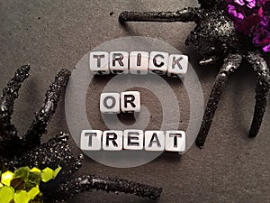 Trick or treat words on black background with spiders Halloween decoration