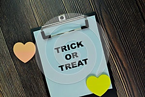 Trick or Treat write on a paperwork isolated on Wooden Table