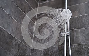Trickles of water flowing from shower head in bathroom closeup photo