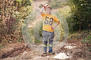 Tricky face boy near the puddle on country road photo