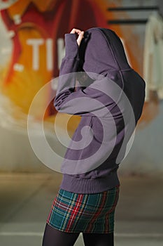 Tricky girl posing in violet fleece sweatshot with hood. Back view photo