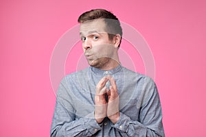 Tricky mature man thinking looking with hand together over pink background