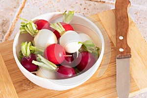 tricolor radishes in a bowl on a table