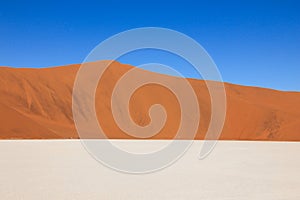Tricolored graphical desert with dunes, salt pan, sky. Sossusvlei, Namibia