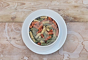 Tricolored rotini in a white ceramic bowl