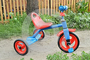 Tricycle kids bike Bicycle blue and red new is on the road in the garden to entertain children