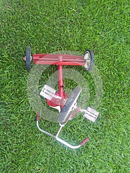 Tricycle upside down on grass