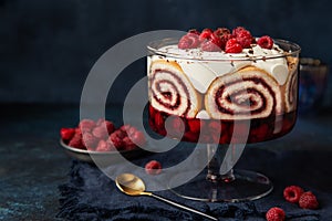 Trifle. Festive layered dessert with berry jelly, swiss roll cake and whipped cream photo