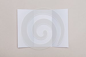 Trifold white template paper on grey background.
