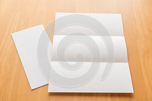 Trifold white template paper on wood background.