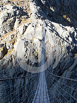 Trift, Switzerland - October 18th 2022: Spectacular rope bridge Triftbruecke crossing a canyon