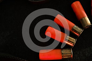 Trigger of a rifle on black background with red lightning with Shotgun shells on a black surface. Ammunition for 12