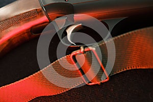 Trigger of a rifle on black background with red lightning