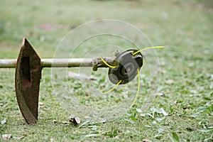 Trimmer head equipment with nylon line cutting grass, Close up.