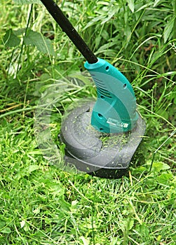 Trimming grass with an electric lawn trimmer