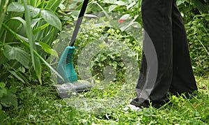 Trimming grass with an electric lawn trimmer