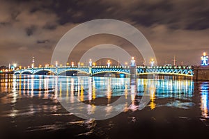 The Trinity Bridge night with backlight illumination lights with reflection in the river Neva, Saint-Petersburg.