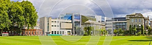 Trinity College Dublin campus with green field and buildings in the background, Ireland. The image features a view of the modern photo