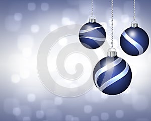 Trio of Blue and Silver Christmas Ornaments on Twinkling Background photo