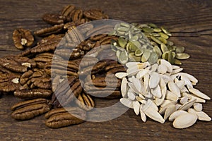 A trio of raw super food nuts, including pecans, raw pumpkin and pumpkin seeds.