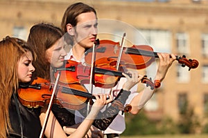 Trio of violinists plays outdoor