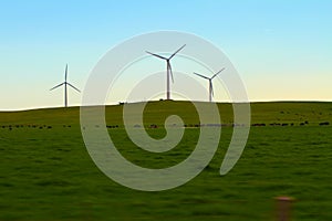 A trio of wind turbine silhouettes at dawn