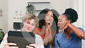 Trio Of Young Friends Collaborating In A Modern Startup Office With Tablet
