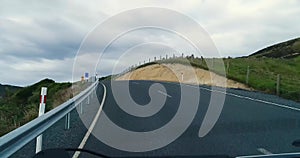 A trip along a winding road through the hills near the shore with rocks.