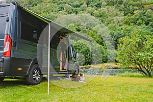 Trip with pet. Happy Brown Dog Border Collie travel by car. Border Collie dog sitting near car camping on grass near mountain