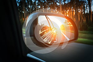 Trip sunset car mirror. Sun, highway car road reflection in mirror. Summer holidays trip concept.