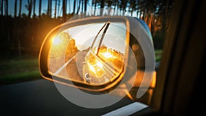 Trip sunset car mirror. Sun, highway car road reflection in mirror. Summer holidays trip concept.