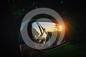 Trip sunset car mirror. Sun, highway car road reflection in mirror. Summer holidays trip concept.