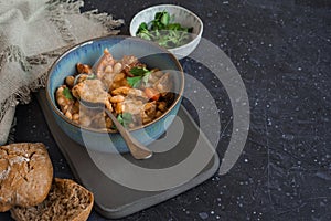 Tripe stew with bread and coriander on the black background photo