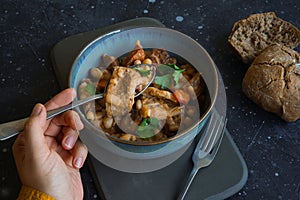 Tripe stew with bread on the black background