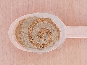 Triphala organic powder in wooden spoon