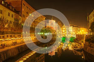 The Triple Bridge over the Ljubljanica River in the city center of Ljubljana and Franciscan church - night picture photo