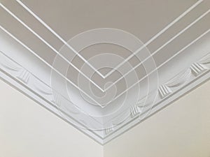 Triple lines and stage opening curtain shaped crown molding in expensive home ceiling at the corner ornamental.