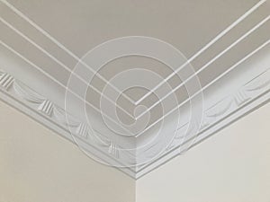 Triple lines and stage opening curtain shaped crown molding in expensive home ceiling at the corner ornamental. Details.