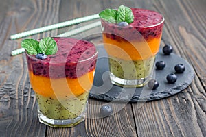 Triple smoothie in glass: kiwi-mint, mandarin-apricot and strawberry-blueberry