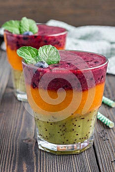 Triple smoothie in glass: kiwi-mint, mandarin-apricot and strawberry-blueberry