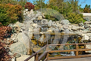 Triple waterfall splits into three streams in Japanese garden. Public landscape park of Krasnodar or Galitsky Park, Russia