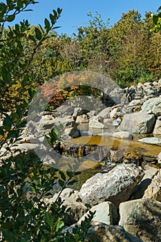 Triple waterfall splits into three streams in Japanese garden. Public landscape park of Krasnodar or Galitsky Park, Russia
