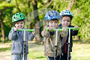 Triplets boys, compete in riding scooters photo