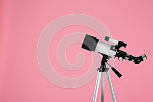 Tripod with modern telescope on pale pink background, space for text