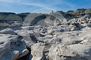 A tripstone field against the dark mountains of the Bisti Badlands