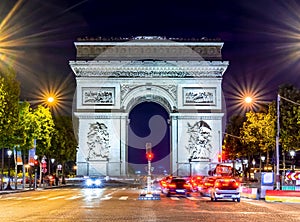 Triumphal arch (Arc de Triomphe) on Champs Elysees avenue at night, Paris, France