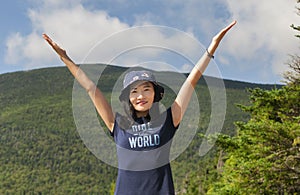 Triumphant woman hiker on top of a mountain summit