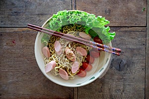 Trockene Instant-Nudeln mit Kirschtomaten, ErdnÃÂ¼ssen, Salat und WÃÂ¼rstchen als Asiatisches Gericht mit EssstÃÂ¤bchen von oben photo