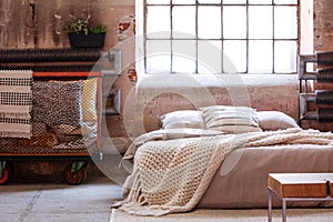 Trolley full of pillows next to a bed in a wabi sabi bedroom interior photo