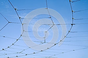 Trolleybus wires against a blue sky with white clouds